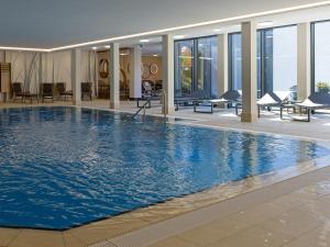 巴特塞森多夫Hotel Schnitterhof的大楼内一个蓝色的大型游泳池