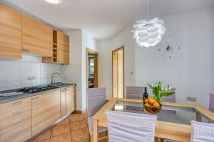 内里吉恩Sv. Jakov Family Apartment - Happy Rentals的厨房配有一张桌子,上面放着一碗水果