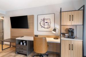 萨凡纳萨凡纳机场江山套房旅馆的客房设有书桌、电视和椅子
