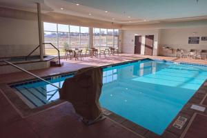 苏福尔斯Comfort Inn & Suites at Sanford Sports Complex的酒店的大型游泳池配有桌椅