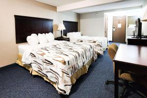 海伦娜Rodeway Inn的酒店客房配有两张床和一张书桌