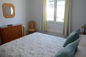 普拉亚布兰卡Sounds of The Sea Apartment的一间卧室配有一张床、镜子和窗户