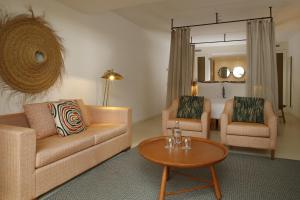 阿尔热祖尔Praia do Canal Nature Retreat的客厅配有沙发、两把椅子和一张桌子