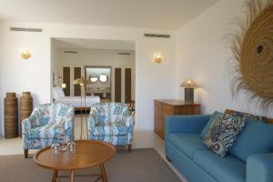 阿尔热祖尔Praia do Canal Nature Retreat的客厅配有蓝色的沙发和两把椅子