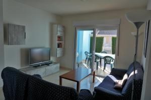 埃尔韦尔赫尔Oasis Park Rosa的客厅配有两把椅子、一台电视和一张桌子