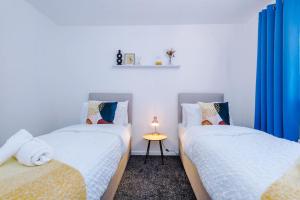 Ocker Hill3 Bed+2 Bath Perfect Contractors & Groups的配有蓝色窗帘的客房内的两张单人床