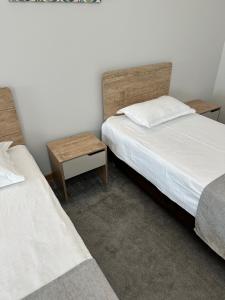 阿斯塔纳PORT INN Hotel的一间卧室配有两张床,中间设有床头柜。