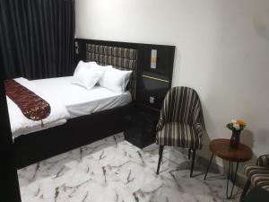 GwarinpaDownunder suites的配有一张床和一把椅子的酒店客房