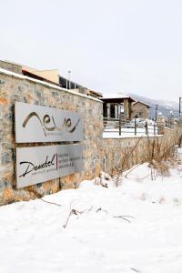 帕雷斯阿吉萨那Domotel Neve Mountain Resort的雪中建筑物上的标志