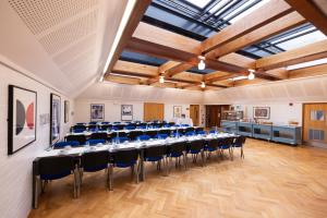 剑桥Harvey Court Gonville and Caius College的一间会议室,配有长桌子和椅子