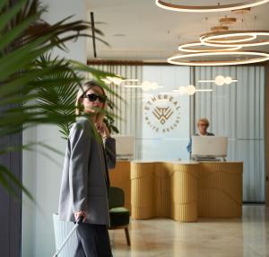 海若克利欧Ethereal White Resort Hotel & Spa的一名妇女站在一个装袋的办公室里