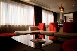 伦敦铂尔曼伦敦圣潘克拉斯酒店的带沙发和玻璃桌的客厅