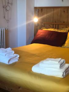 巴尼奥阿里波利La casa di Nello Bini con vista su Firenze的黄色的床,上面有毛巾
