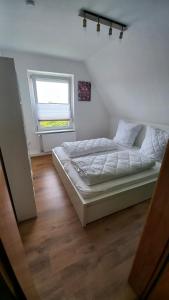 埃姆登Ferienwohnung Dschungel的一间卧室设有一张床和一个窗口