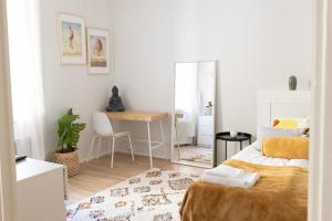 赫尔辛基2ndhomes Fabianinkatu Apartments的一间卧室配有一张床、一张书桌和一面镜子