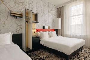 阿姆斯特丹阿姆斯特丹兰开斯特酒店的酒店客房设有两张床和窗户。