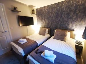 贝尔法斯特Belfast Central 2 Bedroom Luxurious Modern Stay的一间酒店客房,设有两张床和电视