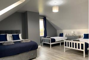 BallynameenForest View House & Hot Tub Sleeps 9的一间卧室配有两张蓝色和白色的床