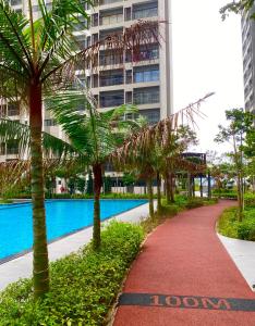 汝来Youth City 2 Bedroom Pool View by DKAY in Nilai的一座建筑前有棕榈树的小径