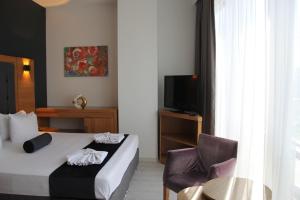 伊斯坦布尔Vplus hotel atasehir的配有一张床和一把椅子的酒店客房