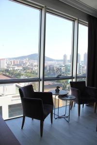 伊斯坦布尔Vplus hotel atasehir的配有椅子和桌子以及大窗户的房间
