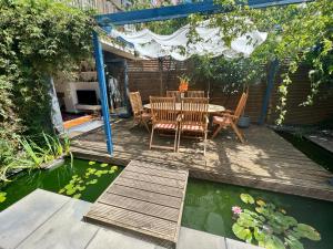 伦敦Urban Oasis Chic 1BR Flat with Spacious Garden的一个带桌椅的庭院和一个池塘