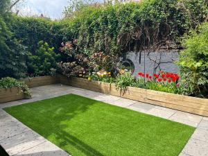 伦敦Urban Oasis Chic 1BR Flat with Spacious Garden的绿草繁花的花园