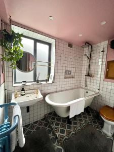 伦敦Urban Oasis Chic 1BR Flat with Spacious Garden的带浴缸、水槽和镜子的浴室