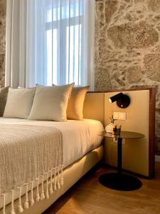 维塞乌VISEU EXECUTIVE Hotel的一间卧室配有一张带桌子和窗户的床