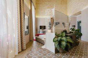 比尔古IBB Hotel Palazzo Bettina Malta的一间卧室配有一张床和盆栽植物