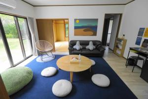 大岛一棟貸しの宿 OKAYADO的客厅配有桌子和沙发