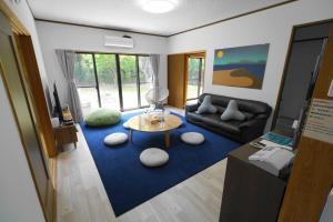 大岛一棟貸しの宿 OKAYADO的带沙发和蓝色地毯的客厅