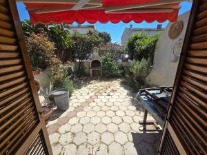 Marina di CerveteriAdria Home House的享有带桌子和遮阳伞的庭院的外部景色。