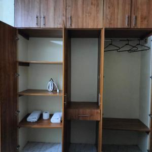 蒙巴萨CND Luxury Homes的衣柜里装有木柜和电话