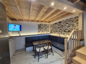 米蒂利尼Ελιά Ξενώνας / Elia Xenonas的一间带桌子和电视的用餐室