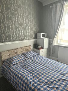 大雅茅斯The Majestic的一间卧室配有一张带蓝白色布艺毯的床