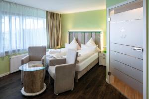 黑尔戈兰岛Insulaner Dependance的酒店客房带一张床、一张桌子和椅子