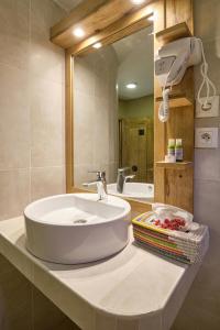 萨利波图尔洛亚姆酒店的浴室的柜台设有水槽和镜子