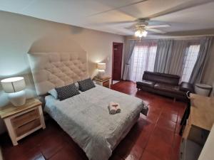伊登维尔Villa Stella Guest House的一间卧室配有一张大床和一张沙发
