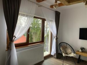 贝利什Tiarra Mountain Lodge的窗户,窗帘和椅子放在房间里