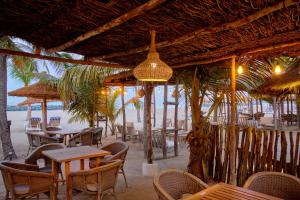 萨利波图尔洛亚姆酒店的海滩上的餐厅,配有桌椅