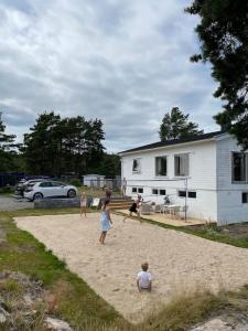 阿伦达尔Summerhouse in south of Norway with privat boat house.的一群人在沙滩上玩风筝