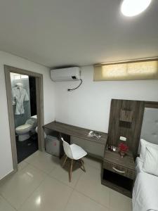 里奥阿查Hotel Juan Pablo 2的一间卧室配有一张床、一张书桌和一个卫生间