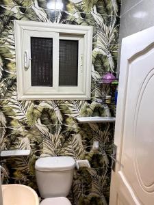 开罗شقة فندقية 108的一间带卫生间的浴室,配有热带壁纸