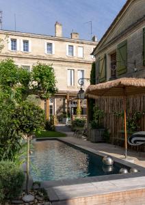 利布尔讷La Maison Mulatô, demeure privée d'hôtes, piscine & spa Libourne, Saint-Emilion的大楼前的游泳池