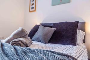 桑德兰Guest Homes - Bambro Flat的一张带紫色枕头的床和一张毯子