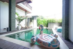 塞米亚克Tropical Beach House Bali的游泳池中间有一个五颜六色的充气剂