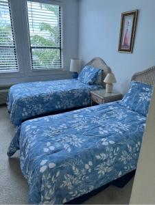 棕榈滩Tropical Palm Beach 2 Bedroom 2 Bathroom Suite POOL -BEACH 2 Blocks Valet Parking Included的配有蓝色床单的客房内的两张床