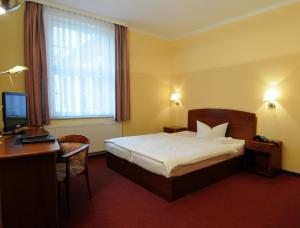 德伯尔恩霍夫德伯尔恩酒店的酒店客房配有一张床、一张书桌和一台电脑