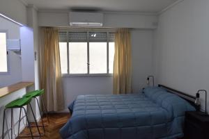 布宜诺斯艾利斯Belgrano Cozy Suite的卧室在窗户前配有蓝色的床